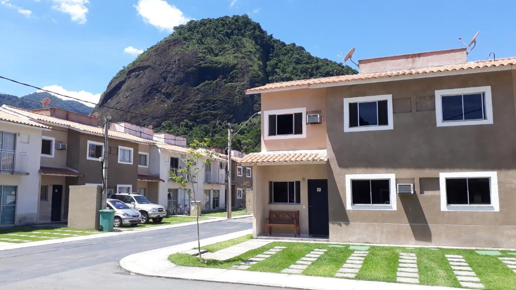 uma casa numa rua com uma montanha ao fundo em Natureza e paz no Sahy em Mangaratiba