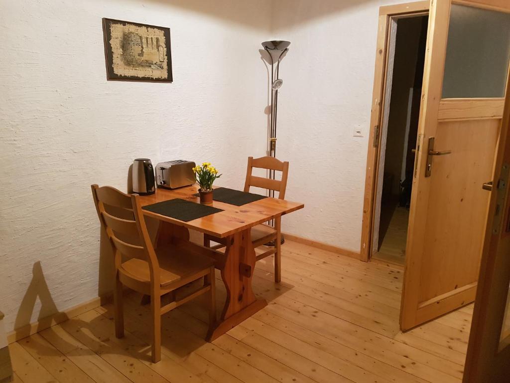 een eettafel met 2 stoelen en een lamp bij Bio Hof Moosburg am See mit Sauna in Güttingen