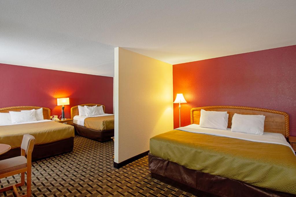 Econo Lodge Inn & Suites في ويسكونسن ديلز: غرفة فندقية بسريرين بجدران حمراء