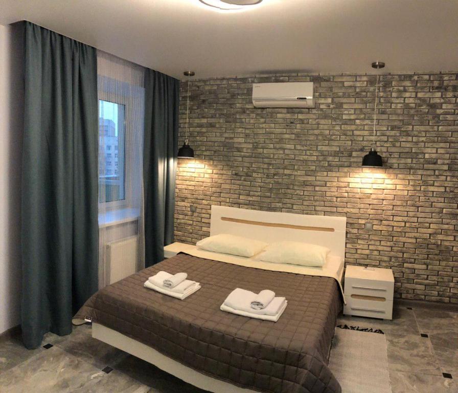 um quarto com uma cama e uma parede de tijolos em Апартаменти Герцена 35 em Kiev