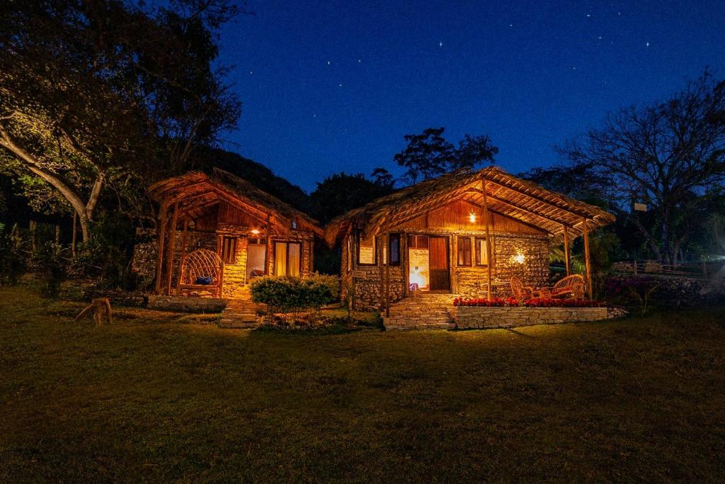 una casa de madera por la noche con sus luces encendidas en Canto del Agua Ecolodge, en Comitán de Domínguez