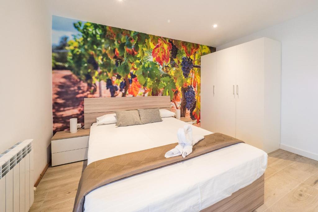 a bedroom with a large bed with a painting on the wall at La Casita de Albelda in Albelda de Iregua