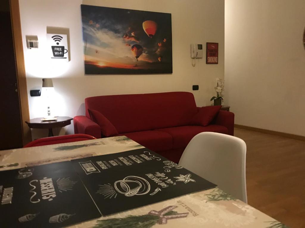 ミラノにあるKibilù - Via Falcone - City Centre - Duomoのリビングルーム(赤いソファ、テーブル付)