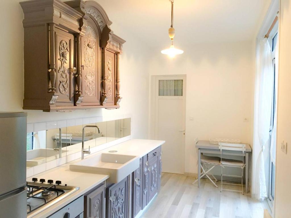 eine Küche mit Holzschränken und einer Spüle in der Unterkunft Maison de ville jardin 2km de Tours in Saint-Pierre-des-Corps