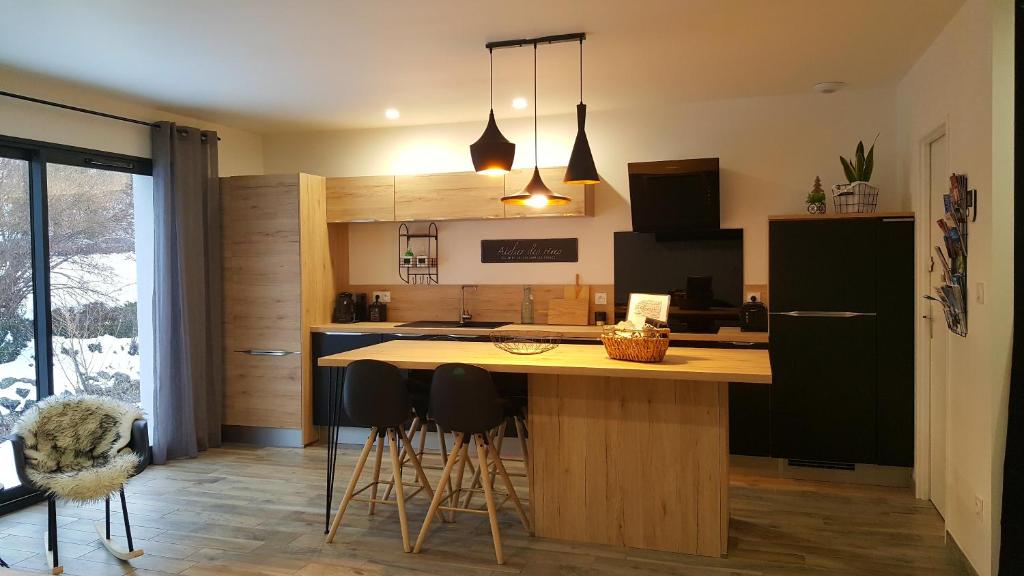 a kitchen with a island with bar stools at MAISON FAMILIALE 3 ch. au CENTRE D'AX in Ax-les-Thermes