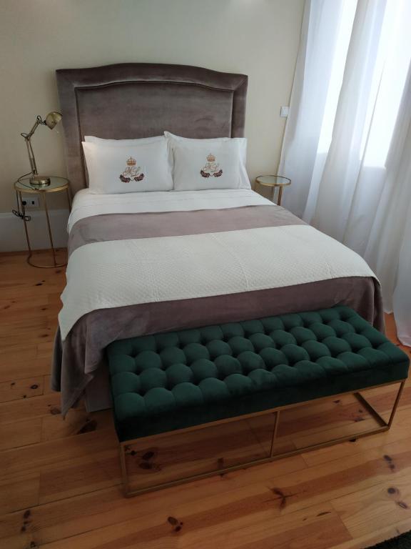 ポルトにあるML Apartments Republicのベッドルームに緑のベンチ付きのベッド1台