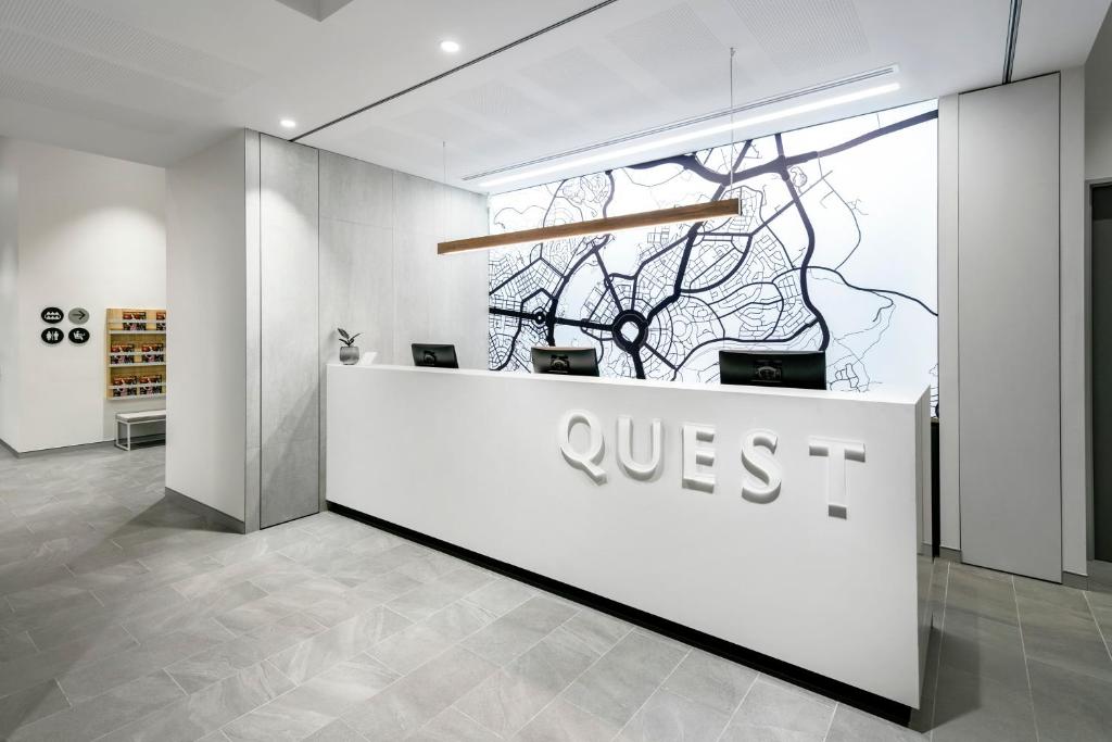 a lobby with a qsis sign on a counter at Quest Canberra City Walk in Canberra