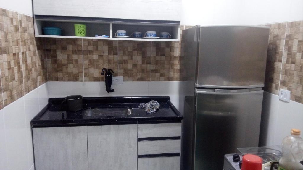 a kitchen with a sink and a refrigerator at Condominio Severos Mar in Ubatuba