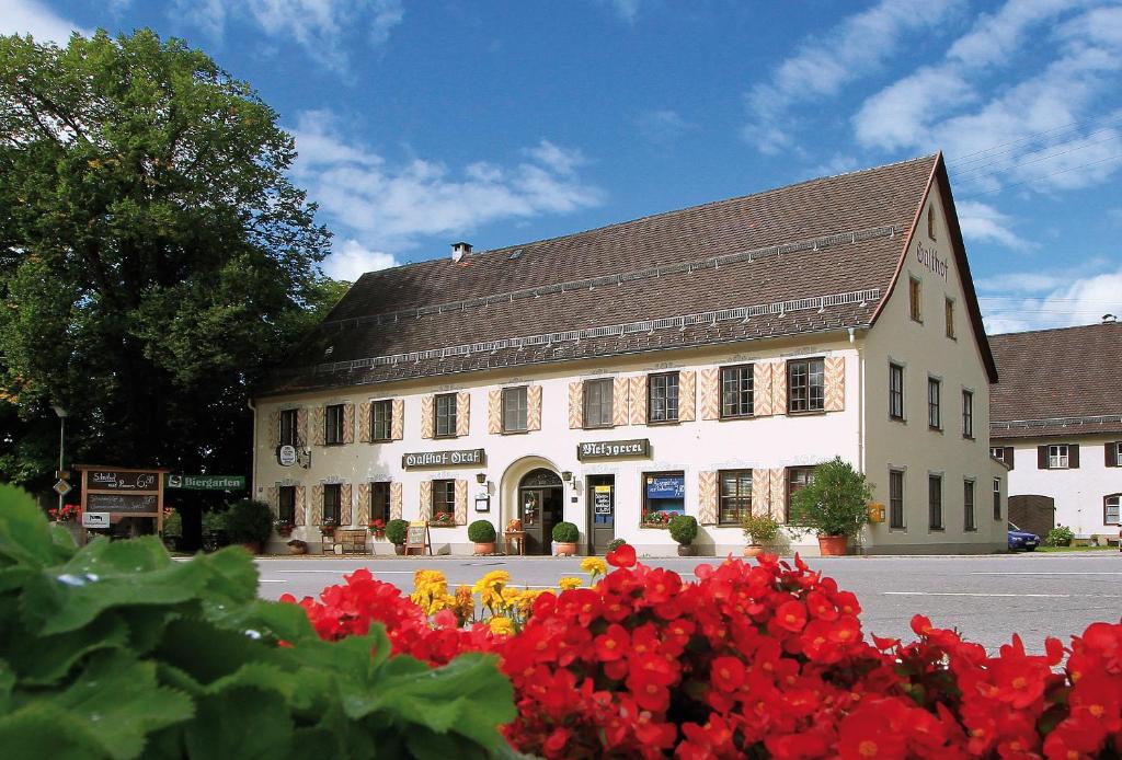 un gran edificio con flores rojas delante de él en Gasthof Graf, en Steingaden