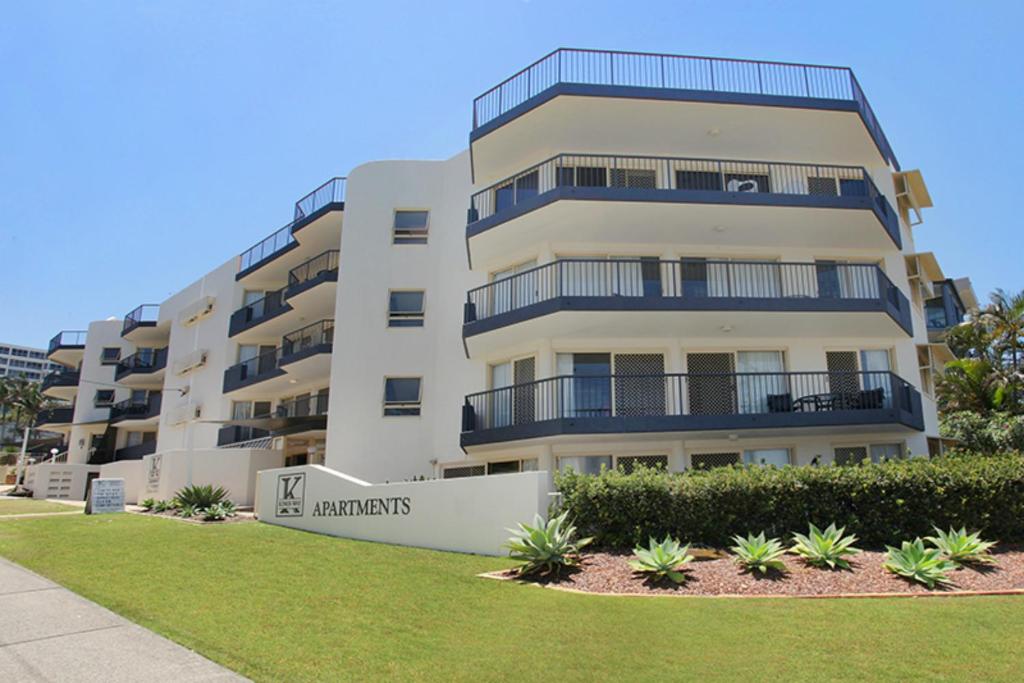 an apartment building with a lawn in front of it at Kings Way Apartments in Caloundra