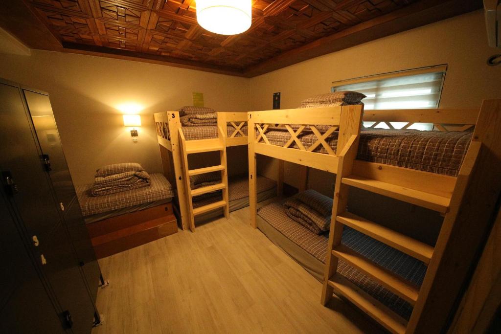 Zimmer mit 2 Etagenbetten und einer Lampe in der Unterkunft Stitches House in Seoul