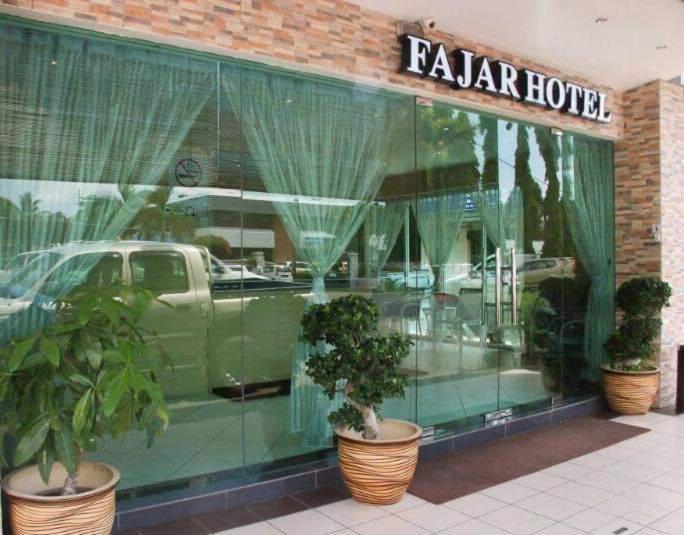 un reflejo de un coche en la ventana de una tienda en Fajar Hotel, en Lahad Datu