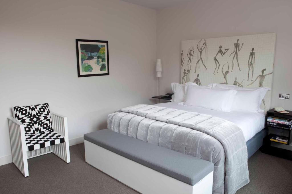 a bedroom with a white bed and a chair at Boundary Shoreditch in London