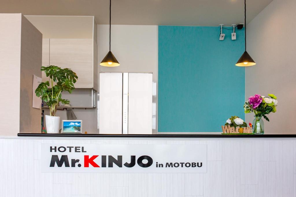 un mostrador de hotel mkt kimno con flores. en Mr.KINJO in MOTOBU OCEAN TERRACE, en Motobu