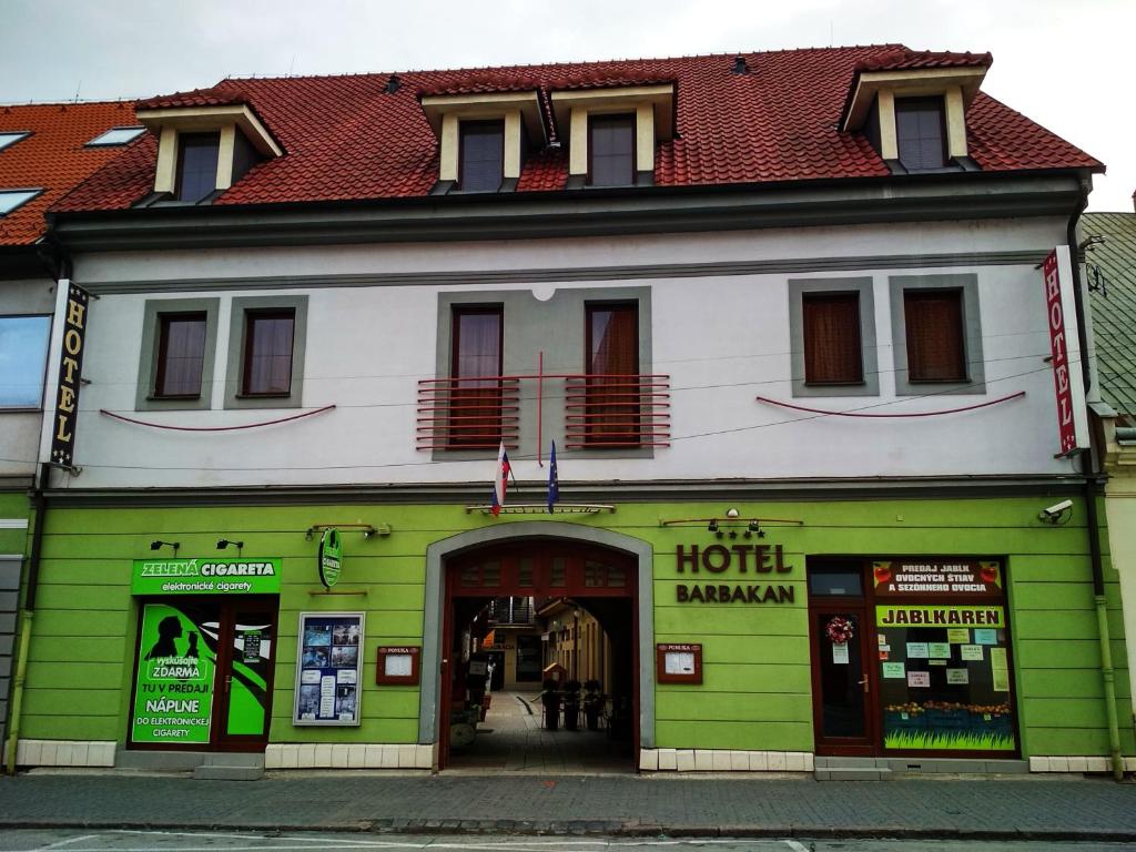 a green and white building with a hotel at Hotel Barbakan in Trnava