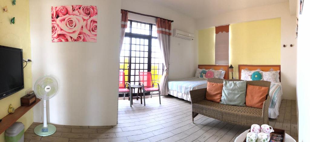 a bedroom with a bed and a couch and a tv at Remember Sea View B&amp;B in Huxi