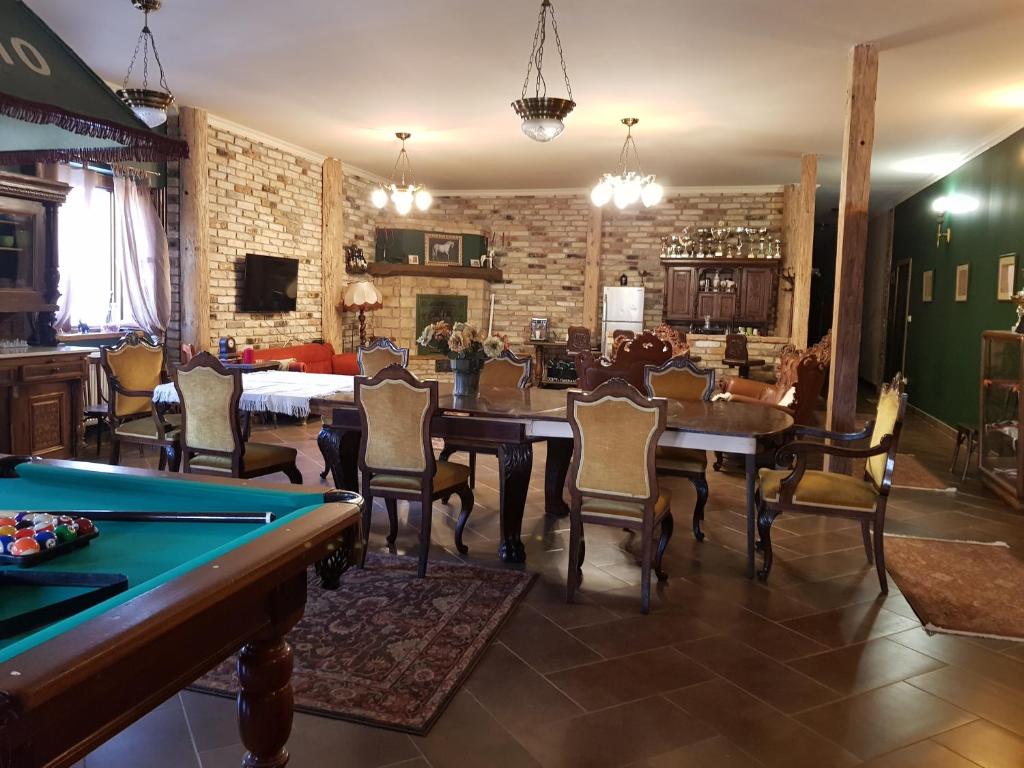 a dining room with a pool table and chairs at Bársonyberek vendégház Bakony in Jásd