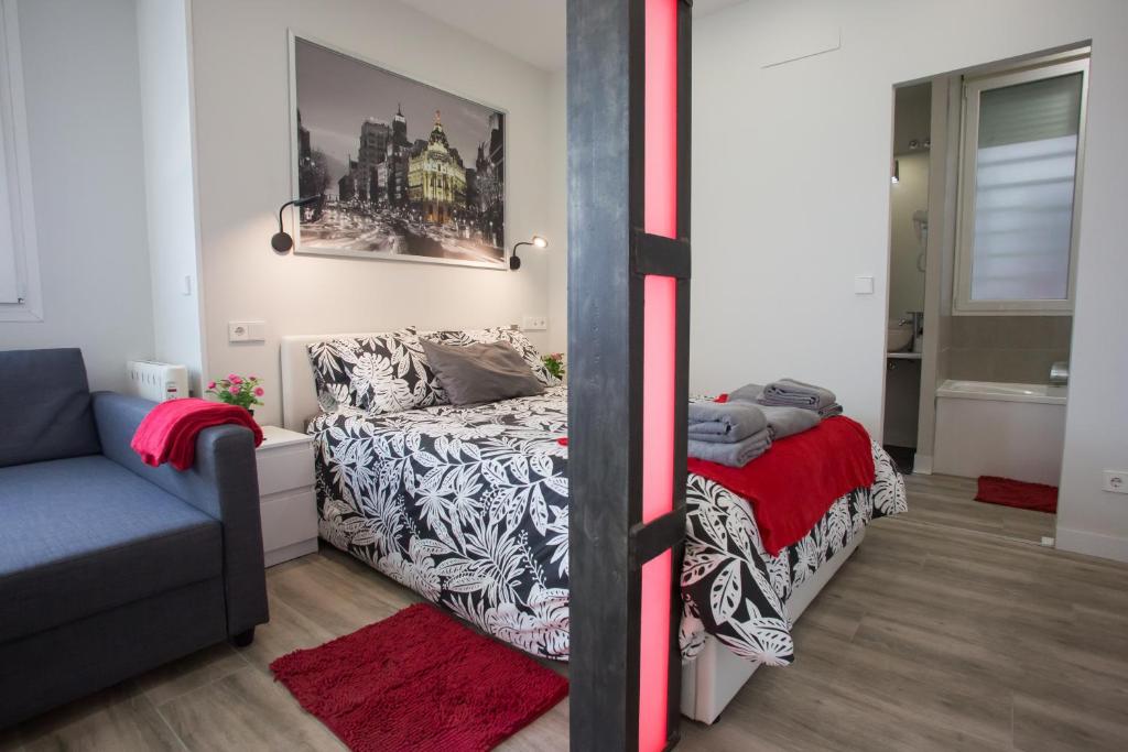 ein Schlafzimmer mit einem Bett und einem Sofa in einem Zimmer in der Unterkunft WindRose 9 in Madrid