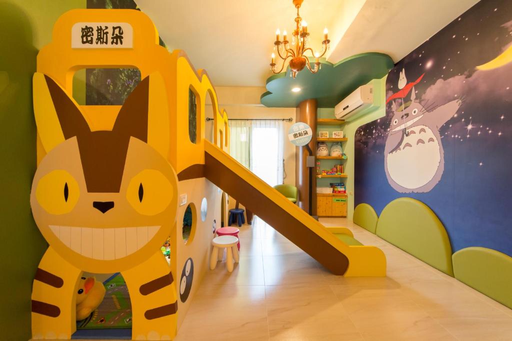 um quarto infantil com um mural de gato e um escorrega em Misto B&B em Taitung City