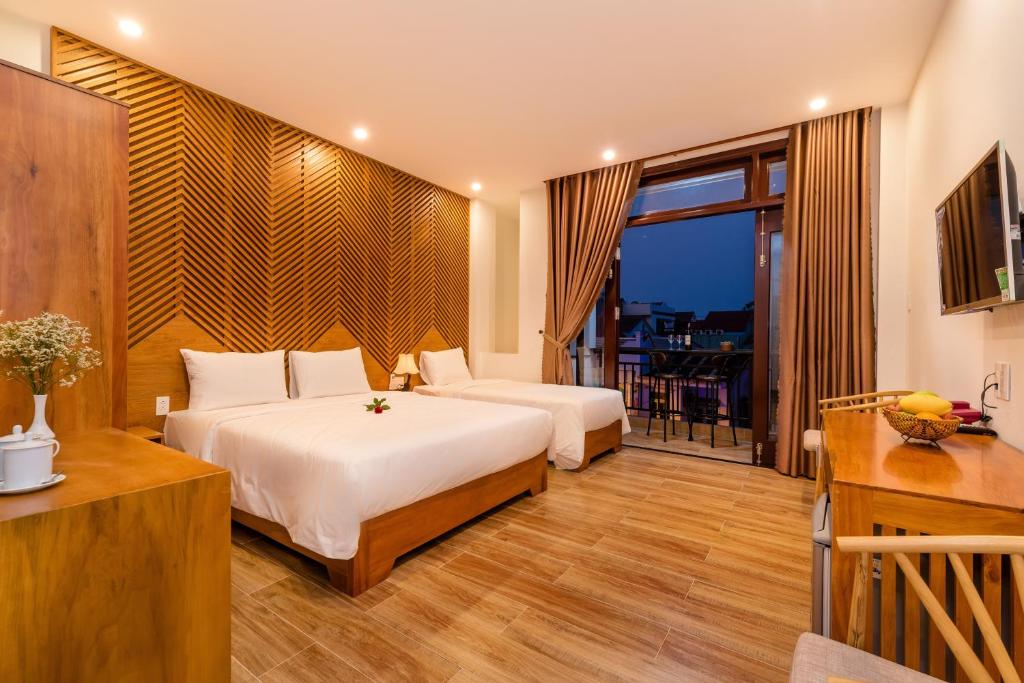 een hotelkamer met 2 bedden en een balkon bij Phong Phu Villa Hoi An in Hội An