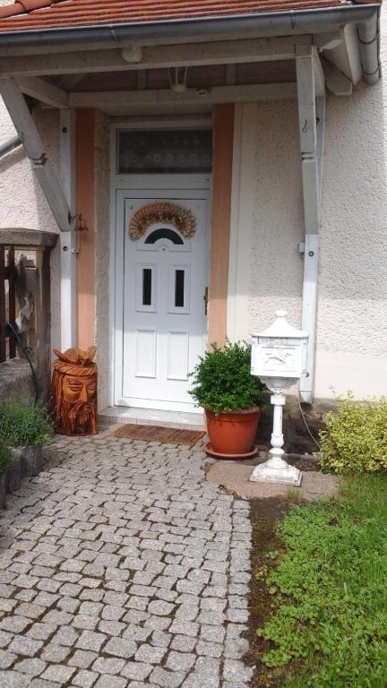a white door of a house with a potted plant at Ferienwohnung Wicke in Thale