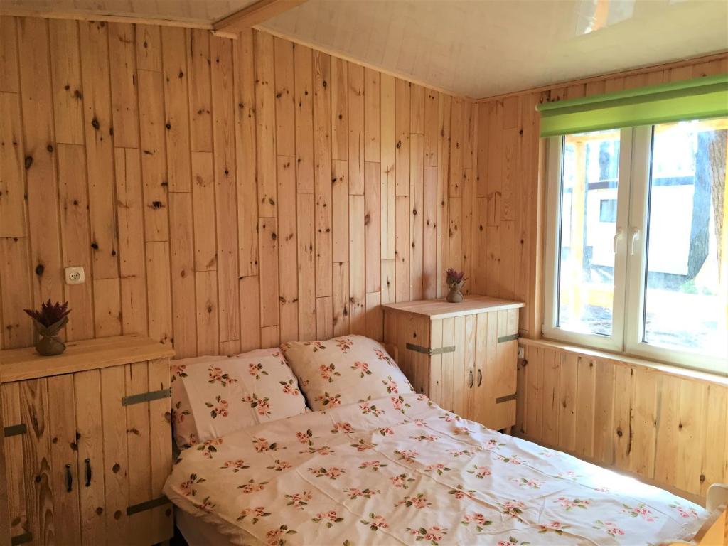 sypialnia z łóżkiem i oknem w obiekcie Domki Nad Jeziorem I Łabędź w Rajgrodzie