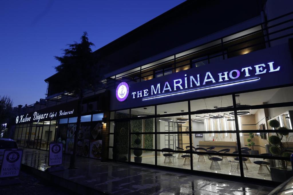 una tienda frente a un puerto deportivo un hotel por la noche en Burhaniye Marina Boutique Hotel, en Burhaniye