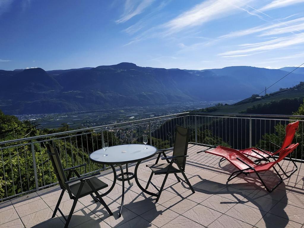 una mesa y sillas en un balcón con vistas en Rebleitenhof en Lana