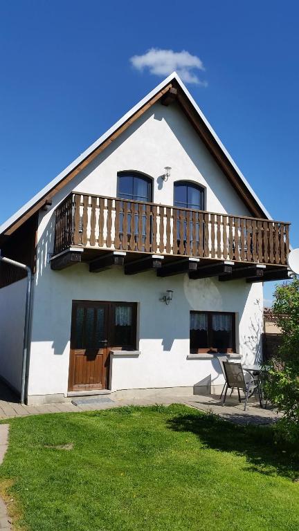 uma casa branca com uma varanda e um relvado em Ferienhaus Stolle em Lawalde