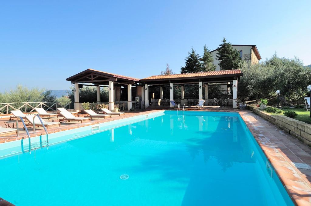 una piscina con sillas y un cenador en Residence Casa Torretta en Gioiosa Marea
