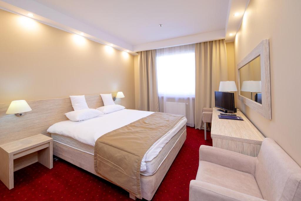 a hotel room with a large bed and a tv at Hotel 500 in Tarnowo Podgórne