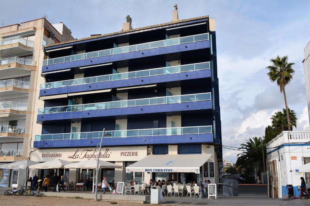niebieski budynek z restauracją przed nim w obiekcie Villa Service-Rodes w mieście Calafell