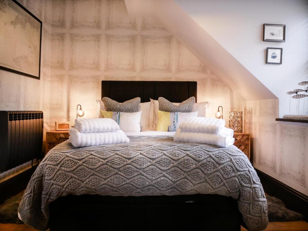 a bedroom with a large bed with pillows on it at Padstow Escapes - Teyr Luxury Penthouse Apartment in Padstow