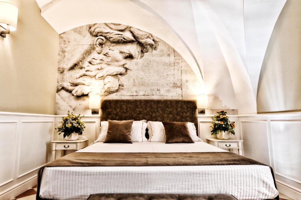 a bedroom with a bed with a wall with a sculpture at Casa Isabella Exclusive Hotel in Mottola