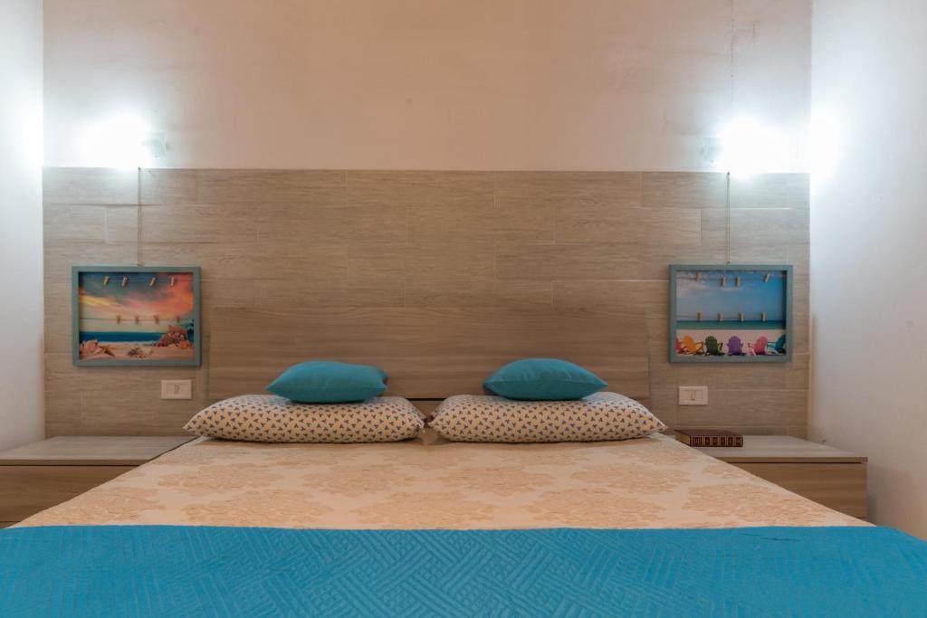 プンタ・プロシュートにあるVilletta Lana 1DXのベッドルーム(青い枕の大型ベッド1台付)
