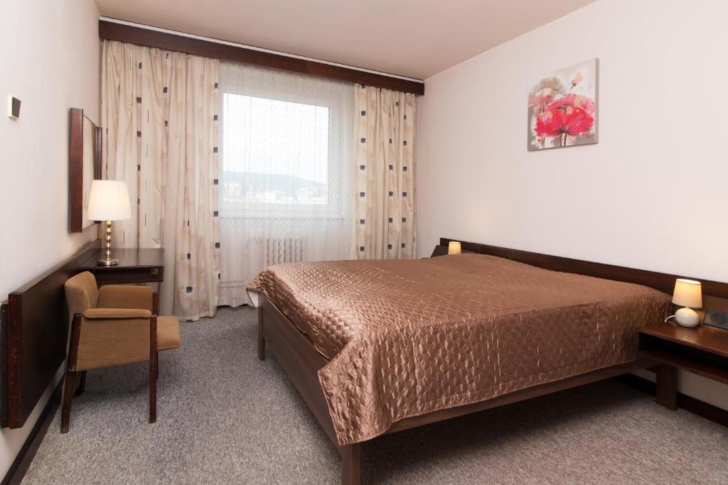 ヤブロネツ・ナド・ニソウにあるホテル メルクール ヤブロネツ・ナド・ニソウのベッドルーム1室(ベッド1台、デスク、窓付)