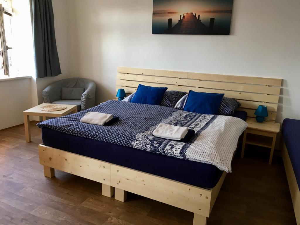 a bedroom with a wooden bed with blue pillows at Apartmany a Ubytovani Mlynice Litovel in Litovel