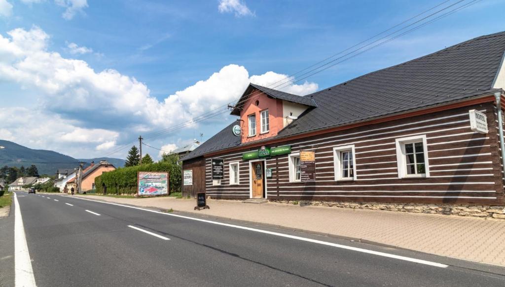 un bâtiment en bois sur le côté d'une route dans l'établissement Penzion Rollba, à Loučná nad Desnou