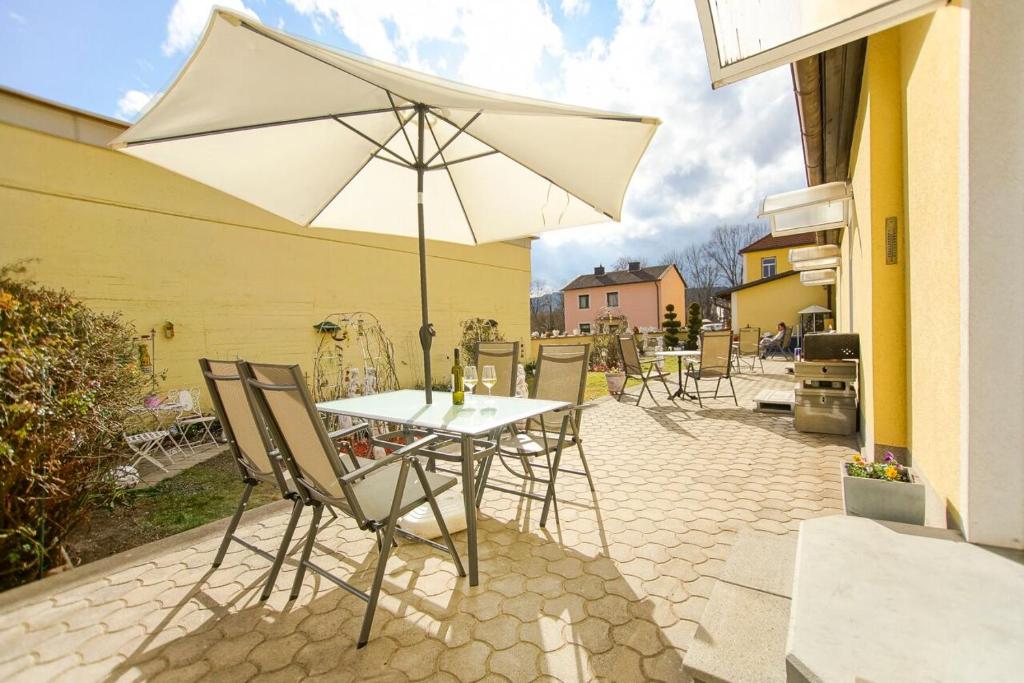 einen Tisch und Stühle mit Sonnenschirm auf einer Terrasse in der Unterkunft AusZeit Leoben 1 mit Terasse und gratis Parkplatz in Leoben