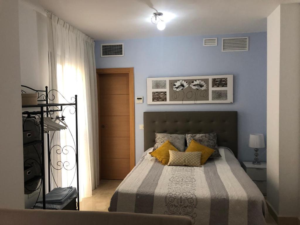 マラガにあるEl Carmen Studioのベッドルーム1室(青い壁のベッド1台、黄色い枕付)