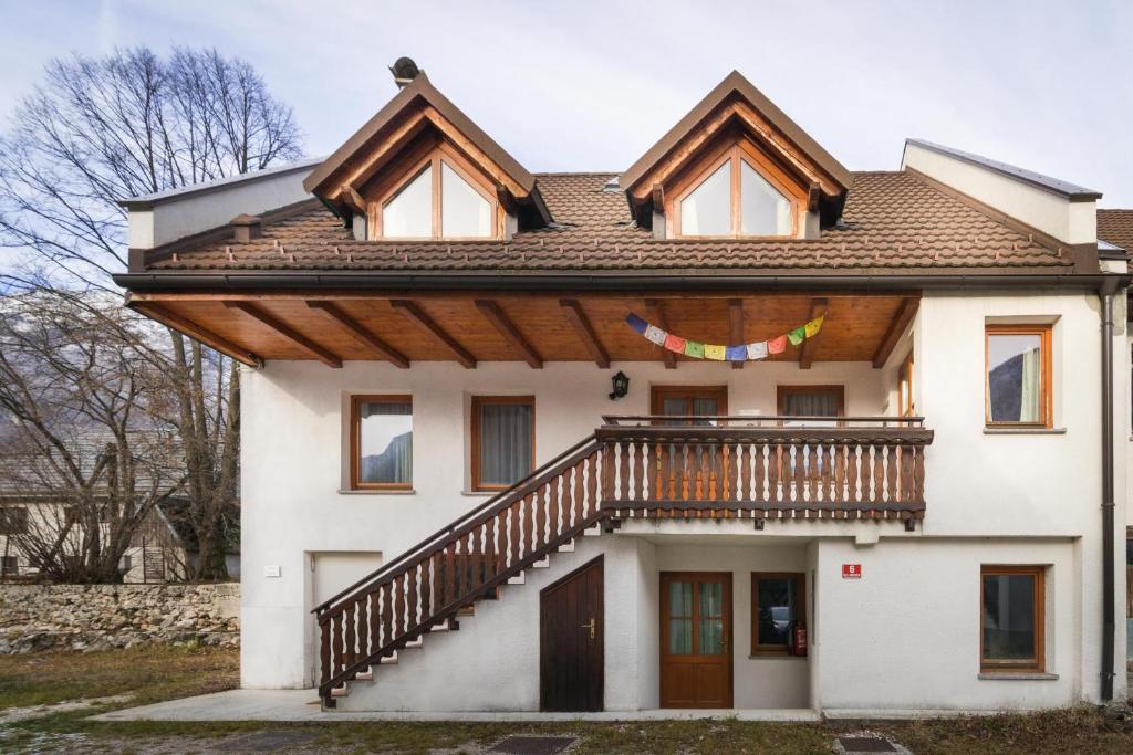 a large white house with a wooden balcony at Koritnica Apartments in Bovec