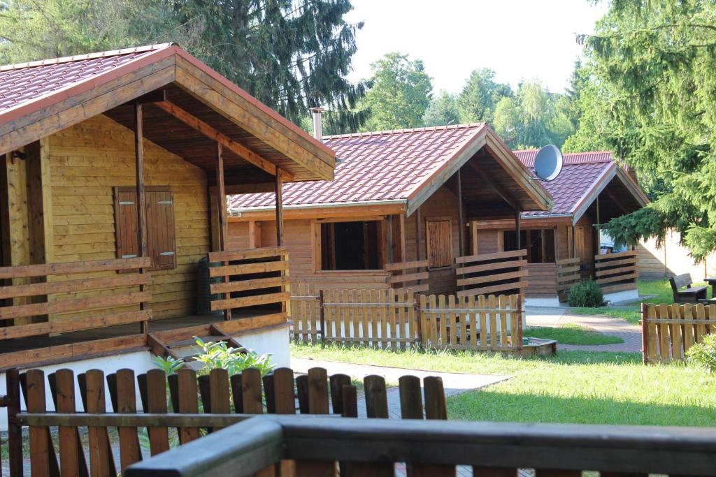 una cabaña de madera con una valla delante en Domki nad jeziorem w Karłowicach, en Karłowice