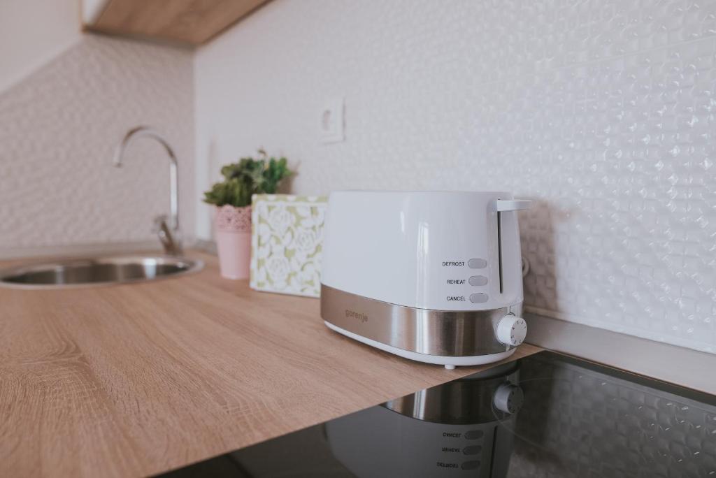 a microwave sitting on top of a counter in a kitchen at Poolside Hideout Apartments in Novalja