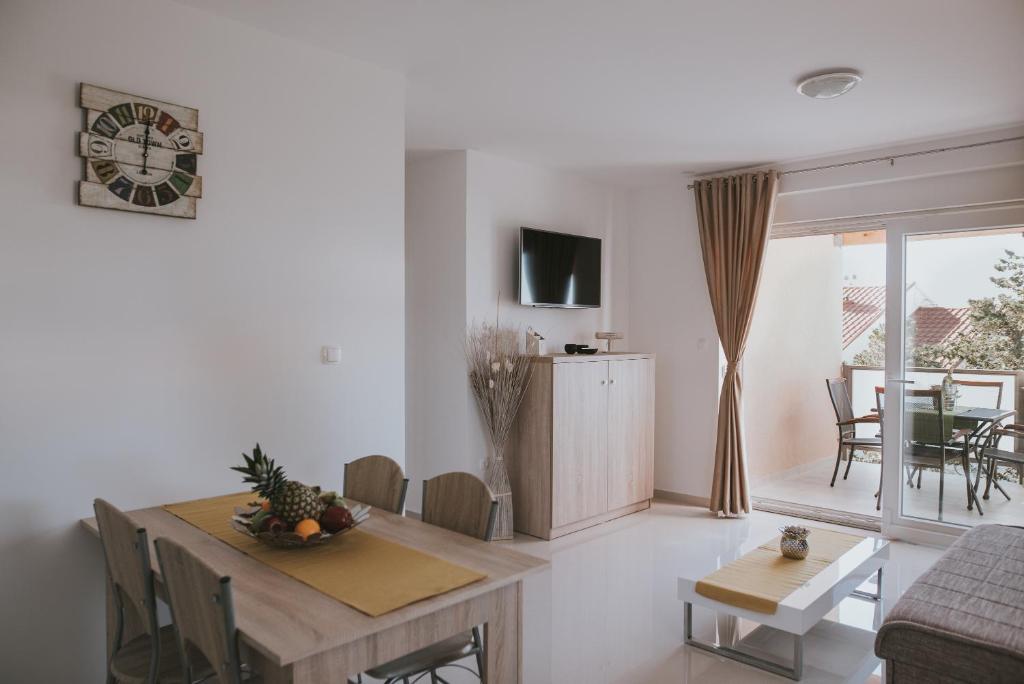 a living room with a table and a dining room at Poolside Hideout Apartments in Novalja