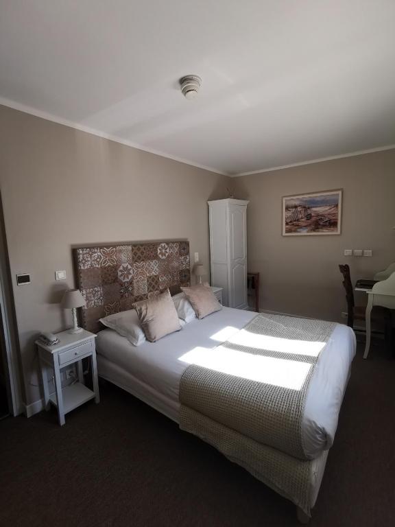 Uma cama ou camas num quarto em Hôtel du Parc