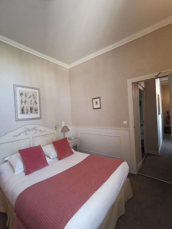 Uma cama ou camas num quarto em Hôtel du Parc