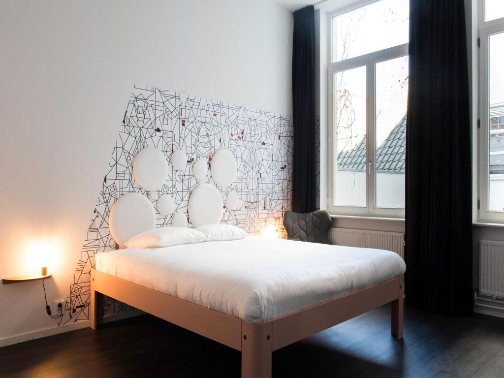 een slaapkamer met een wit bed en een groot raam bij MABI City Centre in Maastricht