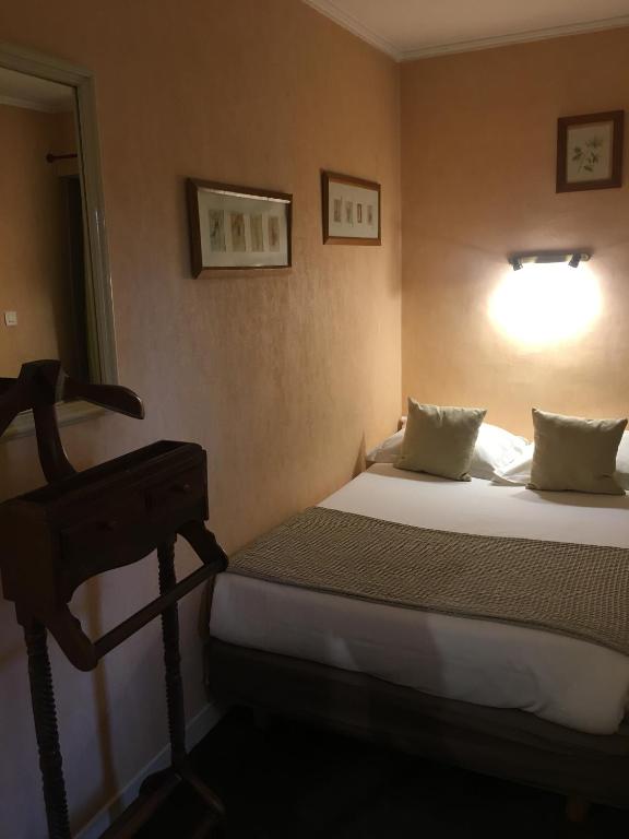 Uma cama ou camas num quarto em Hôtel du Parc