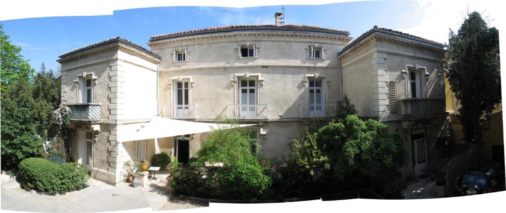 um grande edifício branco com árvores em frente em Hôtel du Parc em Montpellier