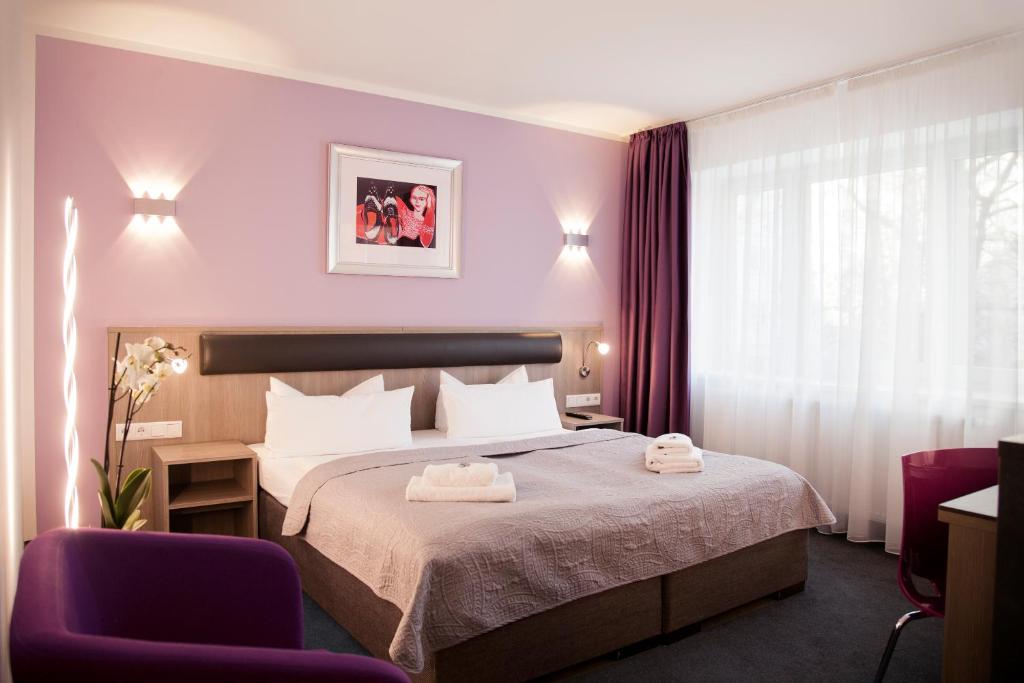 ベルリンにあるホテル ニコライ レジデンスのベッド1台と椅子2脚が備わるホテルルームです。